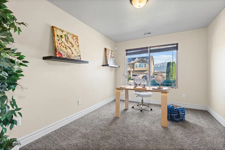 Neutral-toned walls complement the gray carpeting