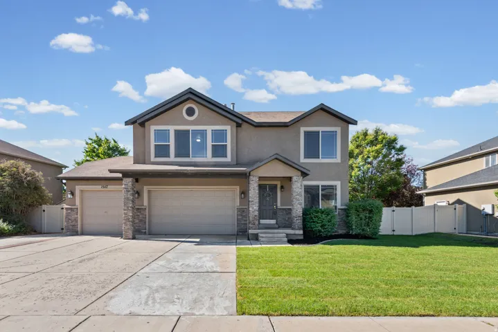 Two-story home with stucco exterior, a two-car garage, and an additional single-car garage
