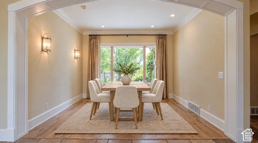 Architectural arched entryway, wood-finish flooring, recessed lighting, and wall-mounted sconces