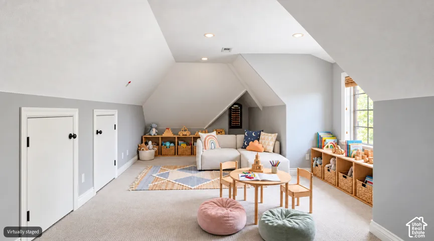 Sloped ceilings with recessed lighting, built-in shelving, two white panel doors, and window with wood-toned blinds