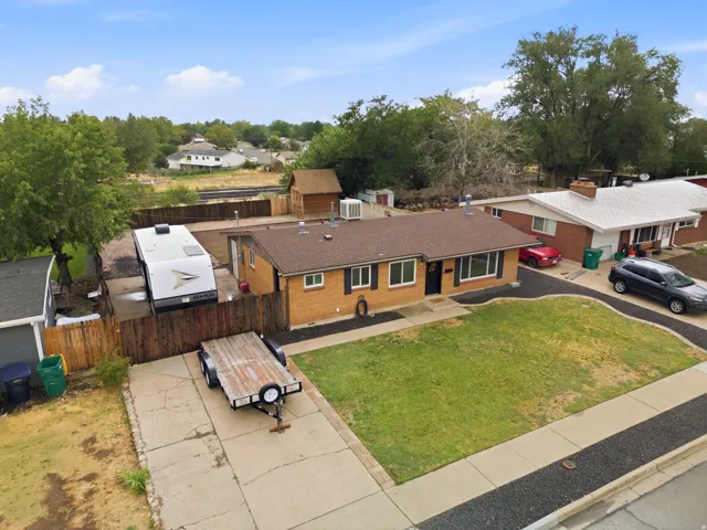 Brick ranch home featuring a spacious front lawn with single-car driveway and RV parkingitional content