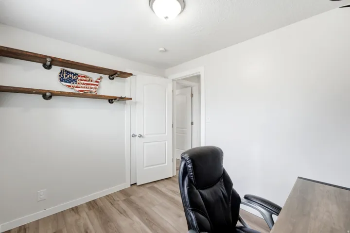 Built-in shelving with wood planks and metal supports, wood-finish flooring, and a flush-mount ceiling light