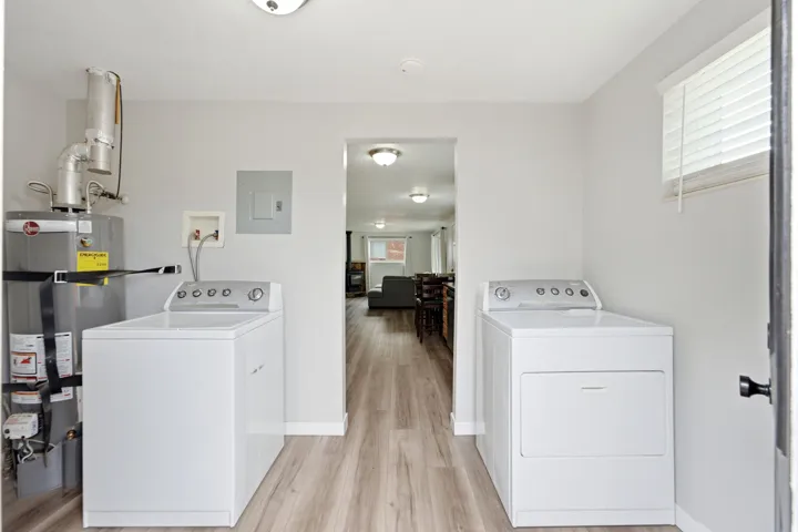 Dedicated laundry area featuring a washer and dryer, wood-finish flooring, and light-toned walls