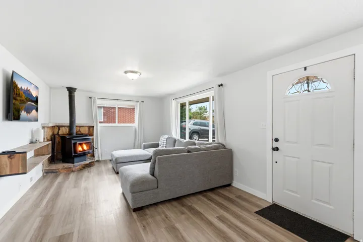Wood-finish flooring throughout, featuring a wood-burning stove with a stone surround