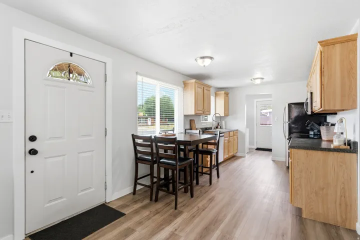 Welcoming entry foyer with white six-panel door and transom window opening to a spacious kitchen and dining area