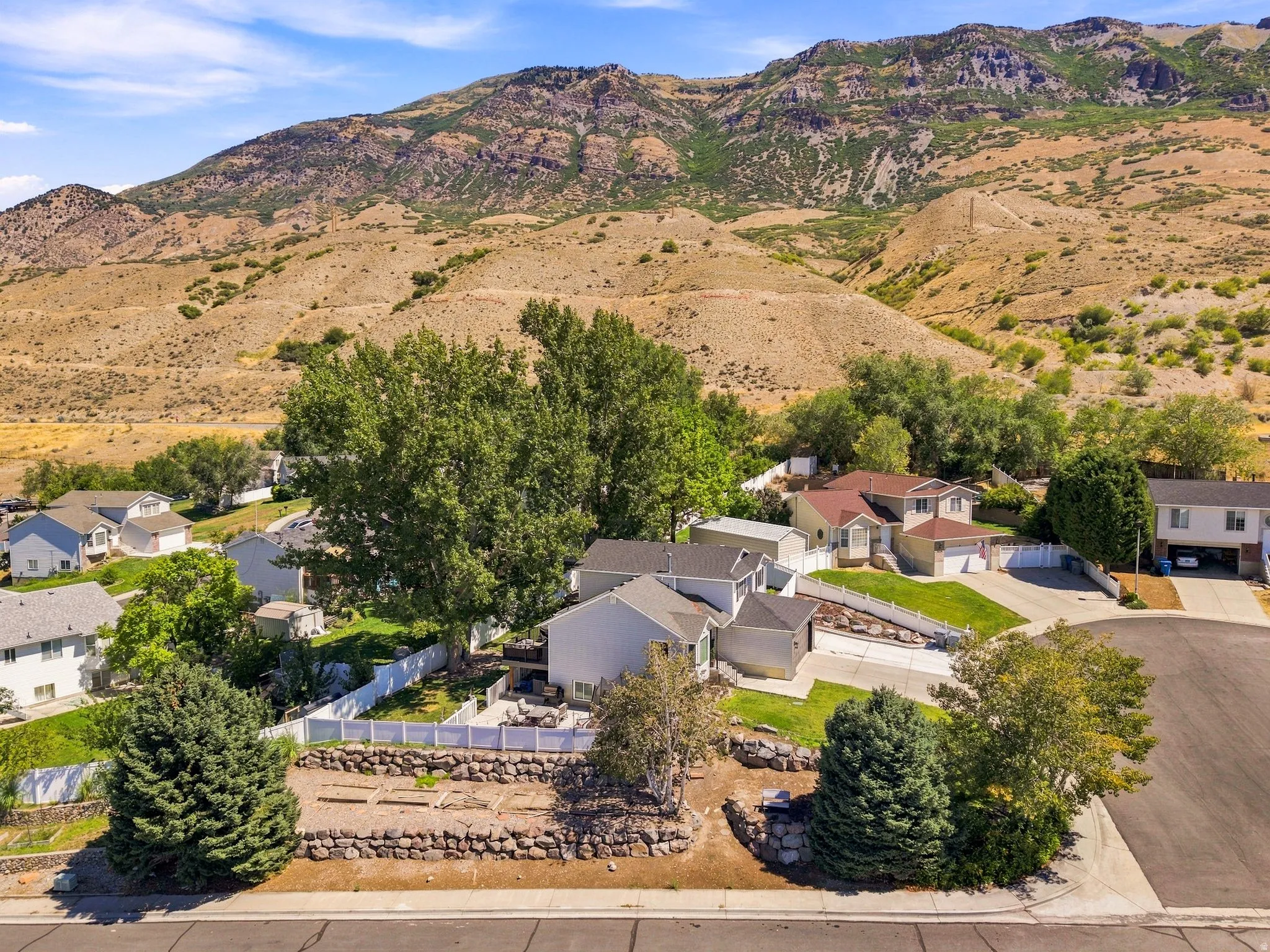 Hillside setting with mature trees and established landscaping