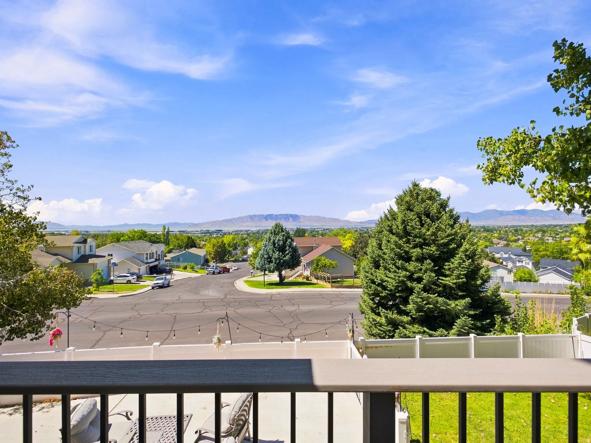 Balcony with composite railing, string lighting, and a suburban landscape