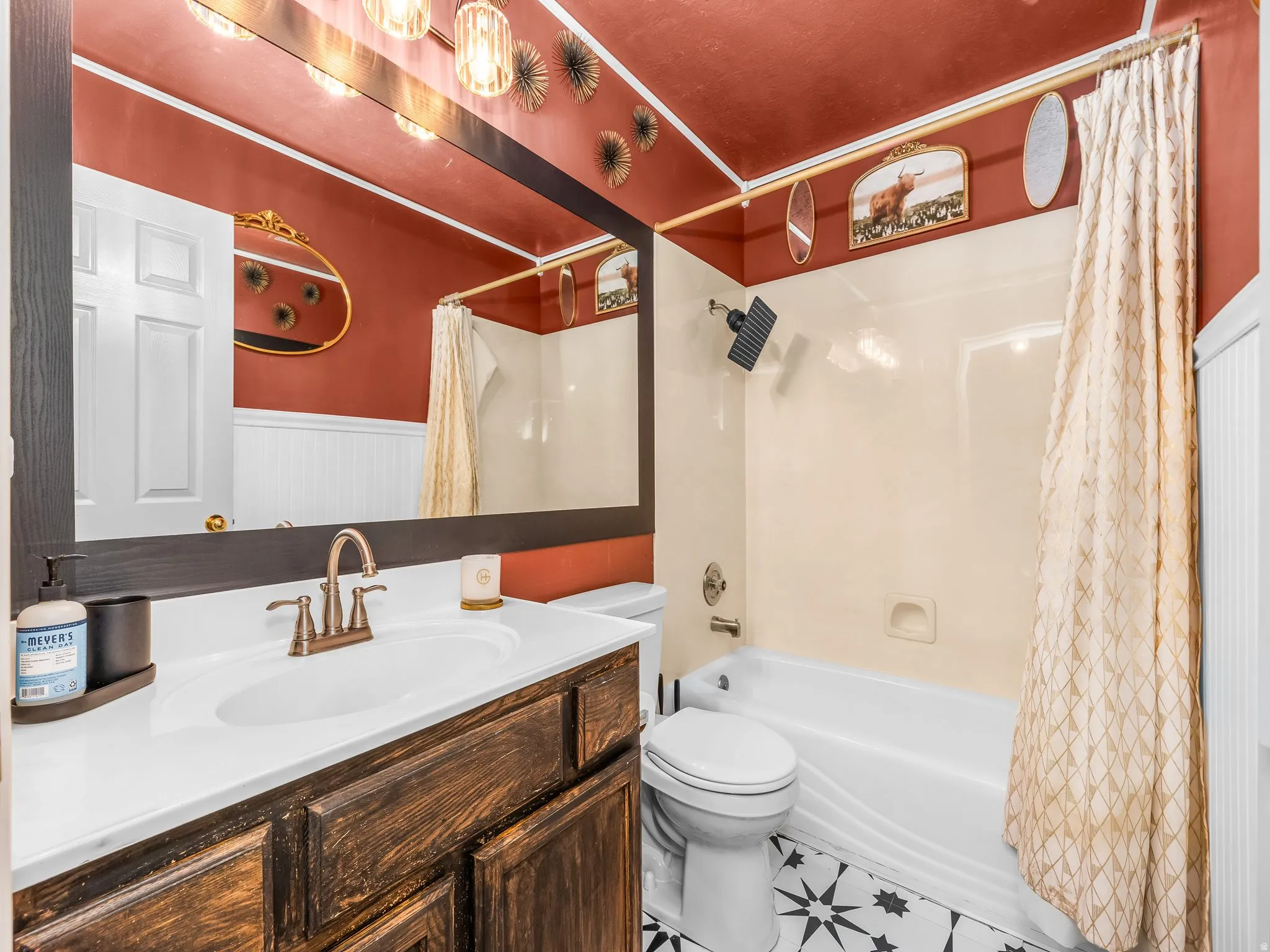 White vanity with a single basin sink and bronze faucet