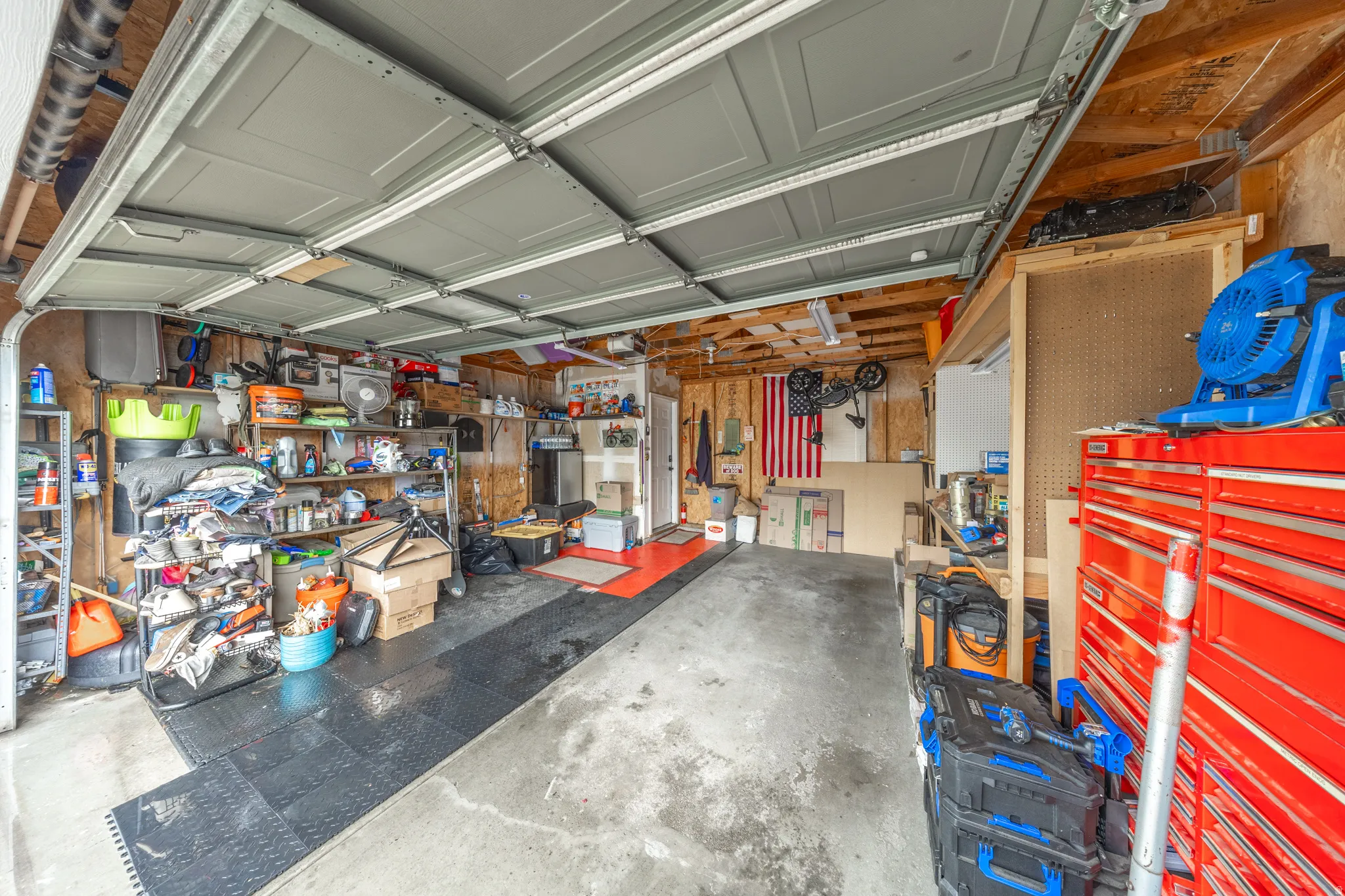 Spacious two-car garage offering abundant storage and workspace, with built-in shelving and plenty of room for tools, equipment, and additional storage.