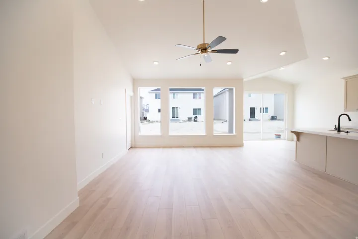 Family room/great room with vaulted ceiling and ceiling fan.