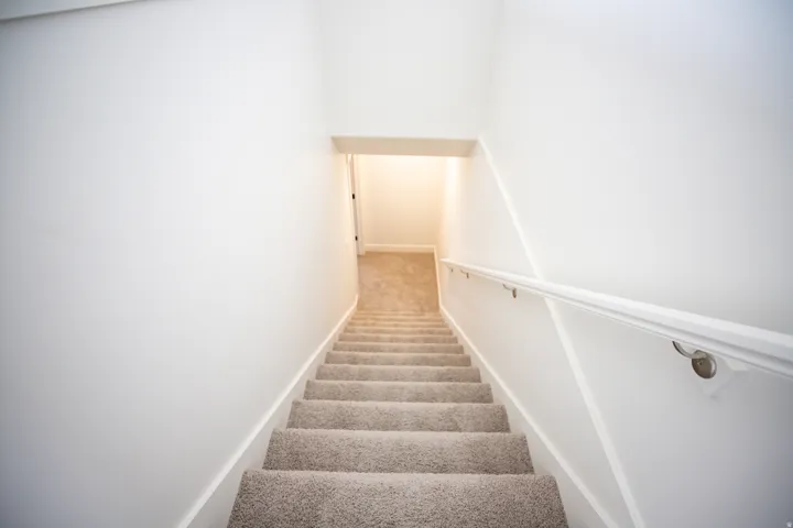 Fully-finished stairs leading to unfinished basement.