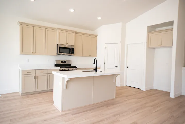 Terrific kitchen with 42" uppers, painted wood cabinets and painted white wood island, quartz slab countertops, gas range, microwave, built-in dishwasher and disposal.