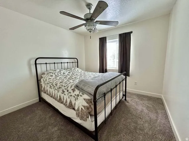 Recessed window with blinds, ceiling fan with light fixture, and neutral wall paint