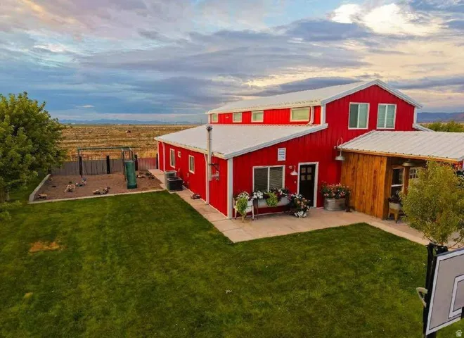 Red-sided residence with a white metal roof and multiple windows