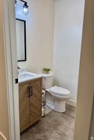 Wood-finish vanity with chevron pattern doors, white countertop, and dark-framed mirror