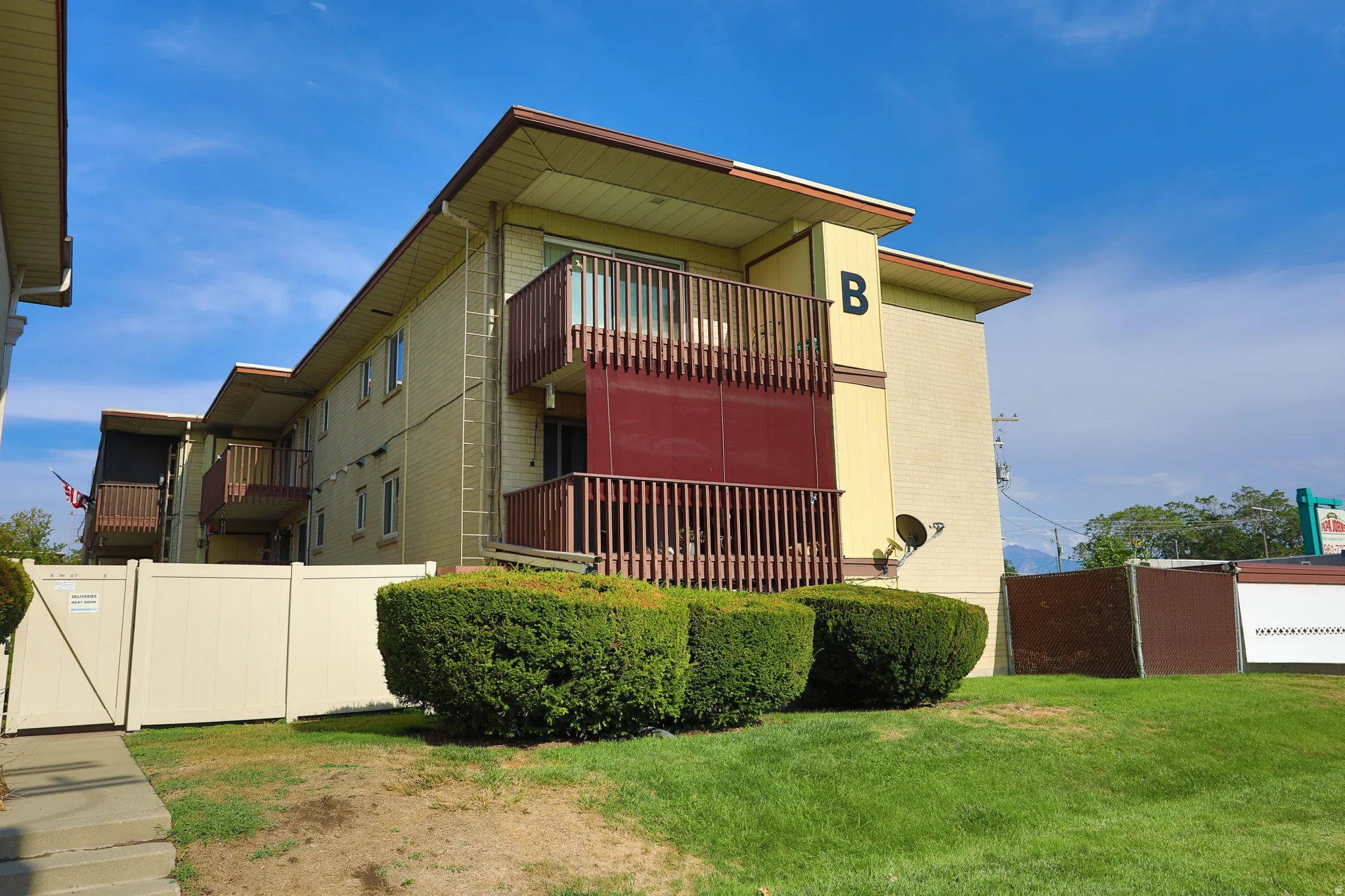 Multi-story building featuring balconies with wood railings and privacy screens
