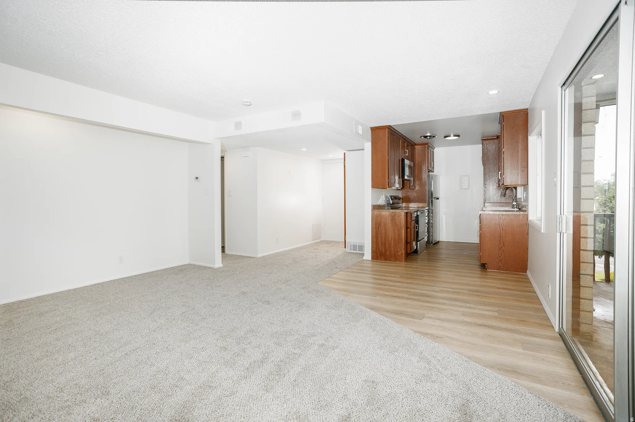 Recessed lighting, wood-finish flooring, sliding glass door, wood cabinetry, built-in stainless steel appliances