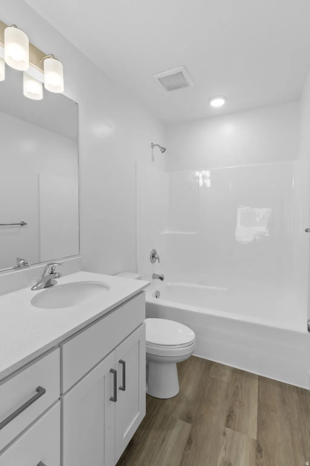 Vanity with quartz-finish countertop and undermount sink, complete with white cabinetry and dark-finish hardware