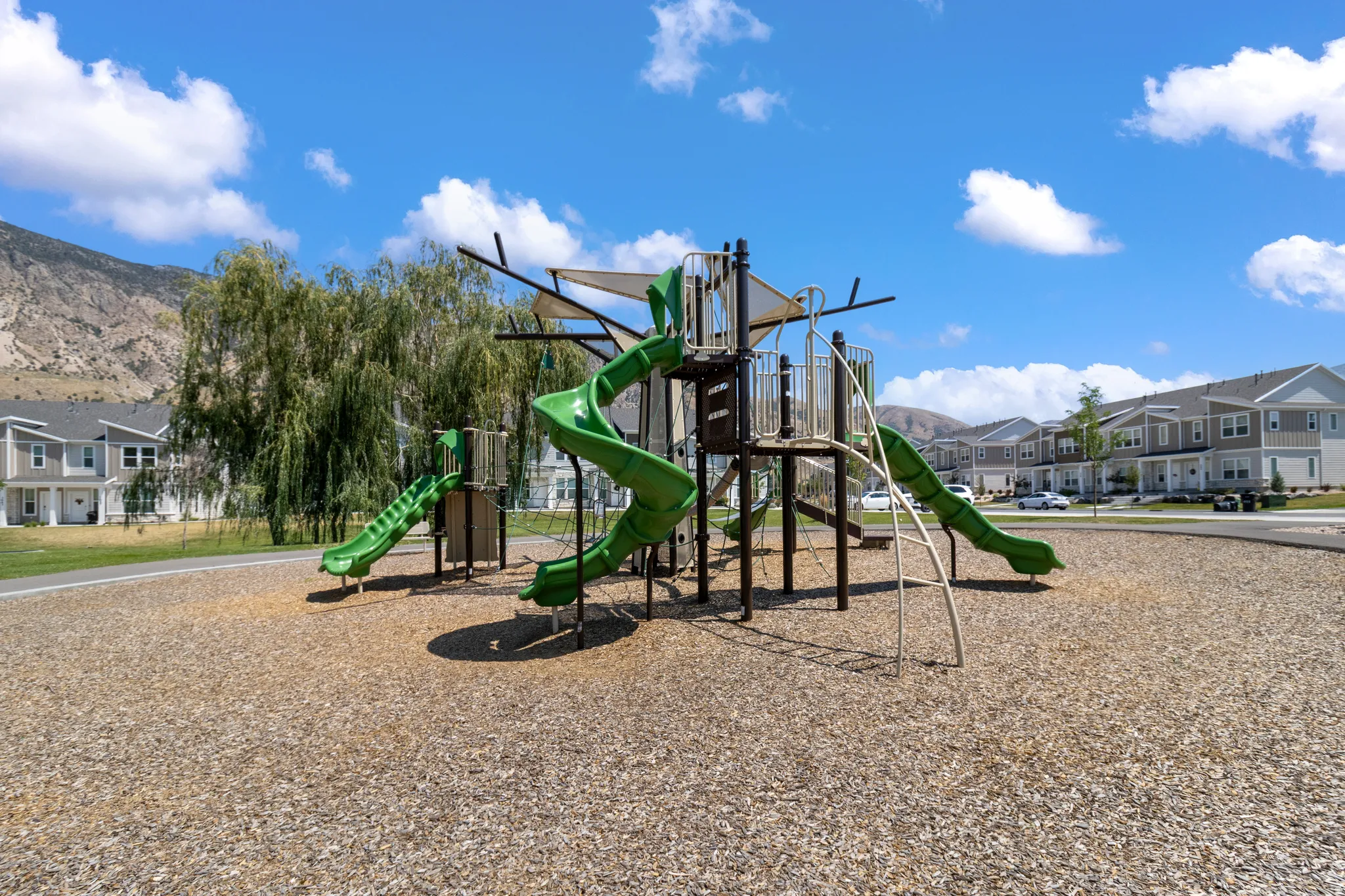 Community playground with multiple slides, climbing elements, and a wood chip surface
