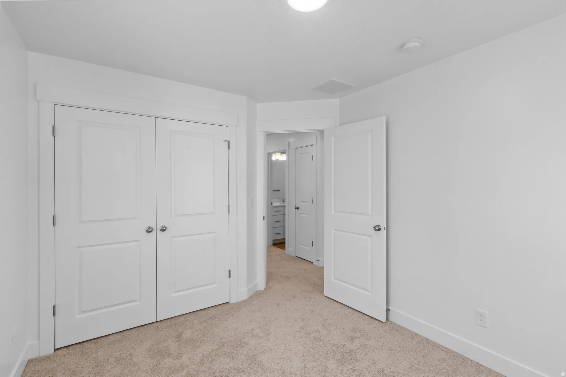 Plush carpeting, white paneled doors, and a neutral wall finish