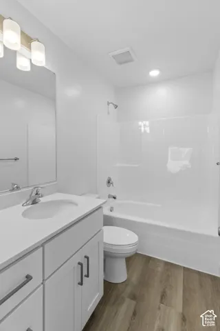 Vanity with quartz-finish countertop and undermount sink, complete with white cabinetry and dark-finish hardware