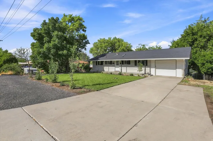 Single-story residence featuring a dark shingle roof, white siding, and an attached garage