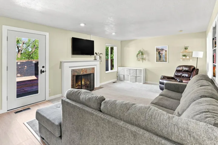 Living area featuring a fireplace with a stone surround, a white mantel, and a built-in hearth