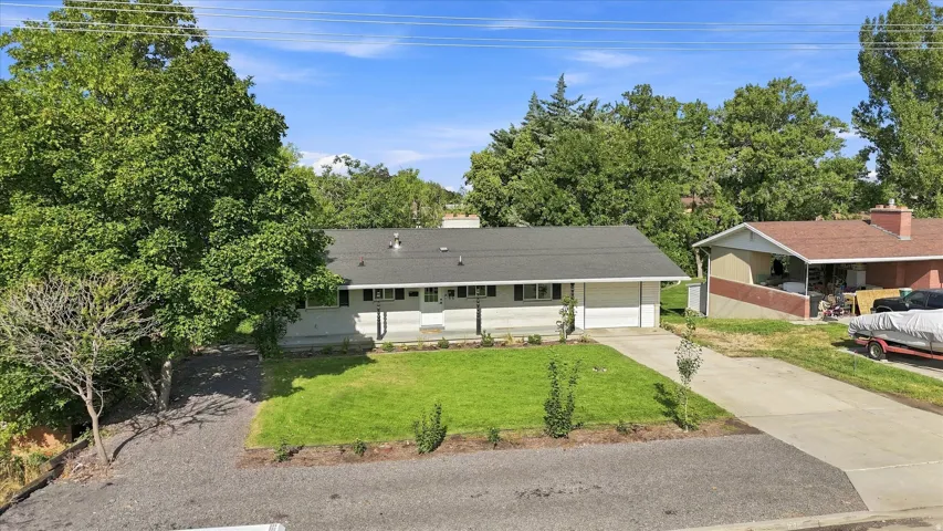 Single-story dwelling with an attached two-car garage, concrete driveway, and front lawn