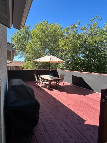 Outdoor wood deck with a red-stained finish and solid privacy fencing