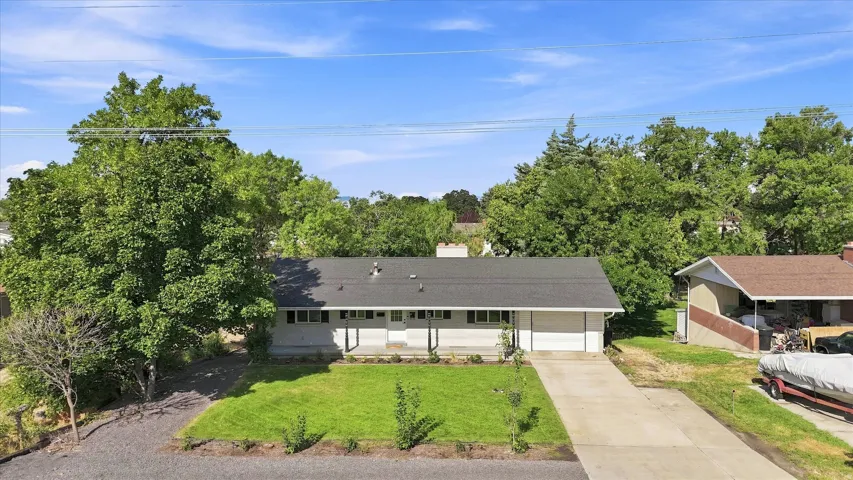 Single-story residence featuring a white exterior, attached two-car garage, and a concrete driveway