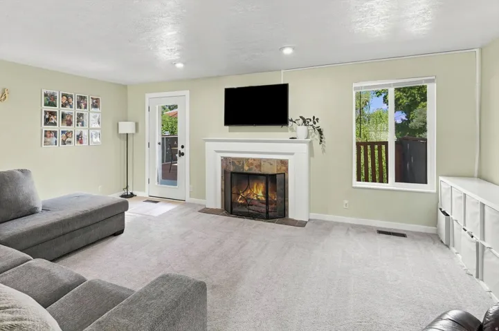 Fireplace with a stone surround, a white mantel, and a hearth