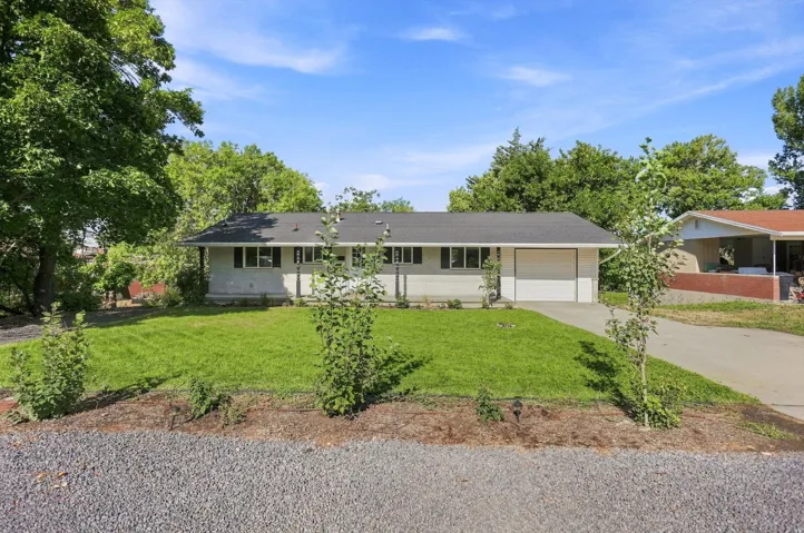Single-story residence with a gray exterior, black shutters, and a dark roof