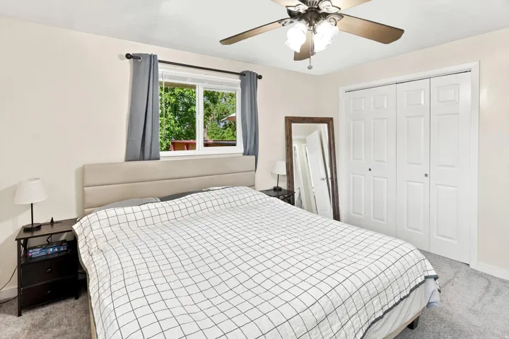 Recessed window, ceiling fan with integrated lighting, paneled closet doors, and light-toned wall finishes