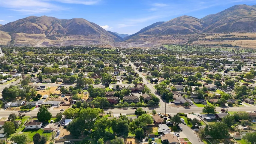Mountain backdrop with expansive residential area featuring mature trees and a golf course