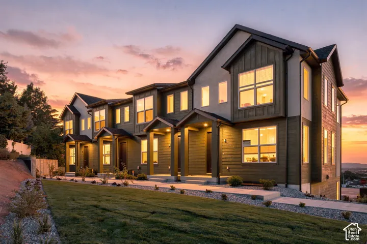 Multi-level exterior featuring horizontal siding, board-and-batten detailing, multiple gabled rooflines, covered entryways, and large picture windows