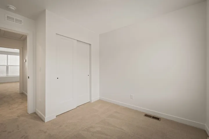 Neutral wall paint with carpeted flooring and white trim