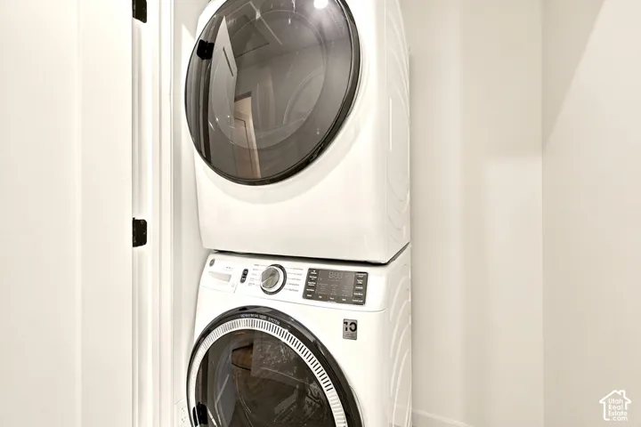 Stacked front-loading washer and dryer unit with digital control panels and glass-front doors