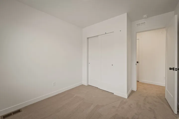 Neutral-toned carpeting, white walls, and white trim
