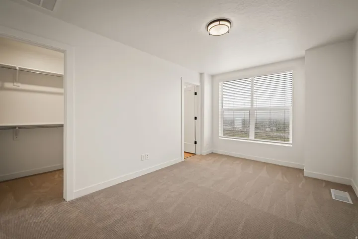 Neutral-toned carpeted flooring complements the crisp white walls