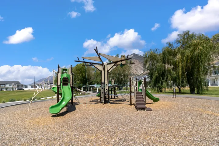 Community playground featuring multiple slides, climbing structures, and shade canopies