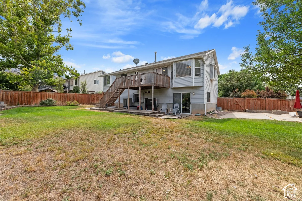 Expansive backyard featuring a multi-level deck, ground-level patio, and sliding glass door access