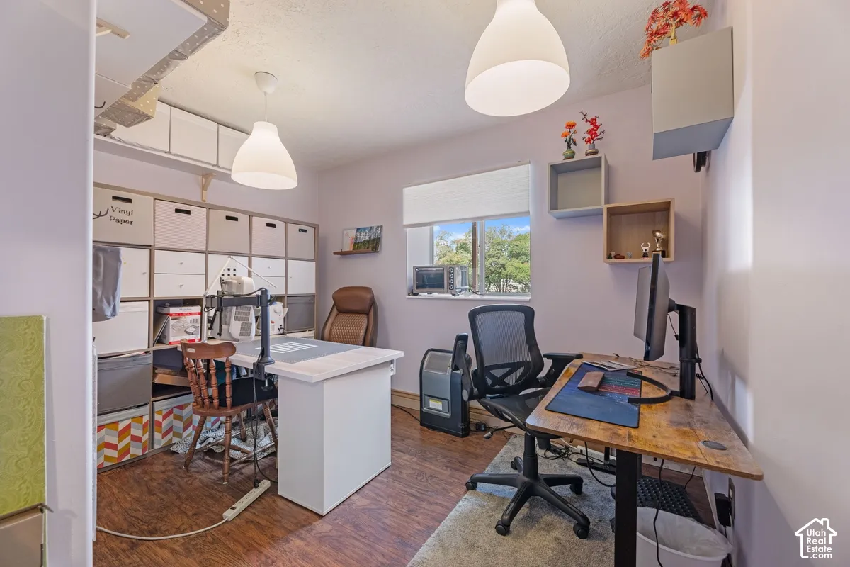 Wood-finish flooring, overhead pendant lighting, and multiple window treatments