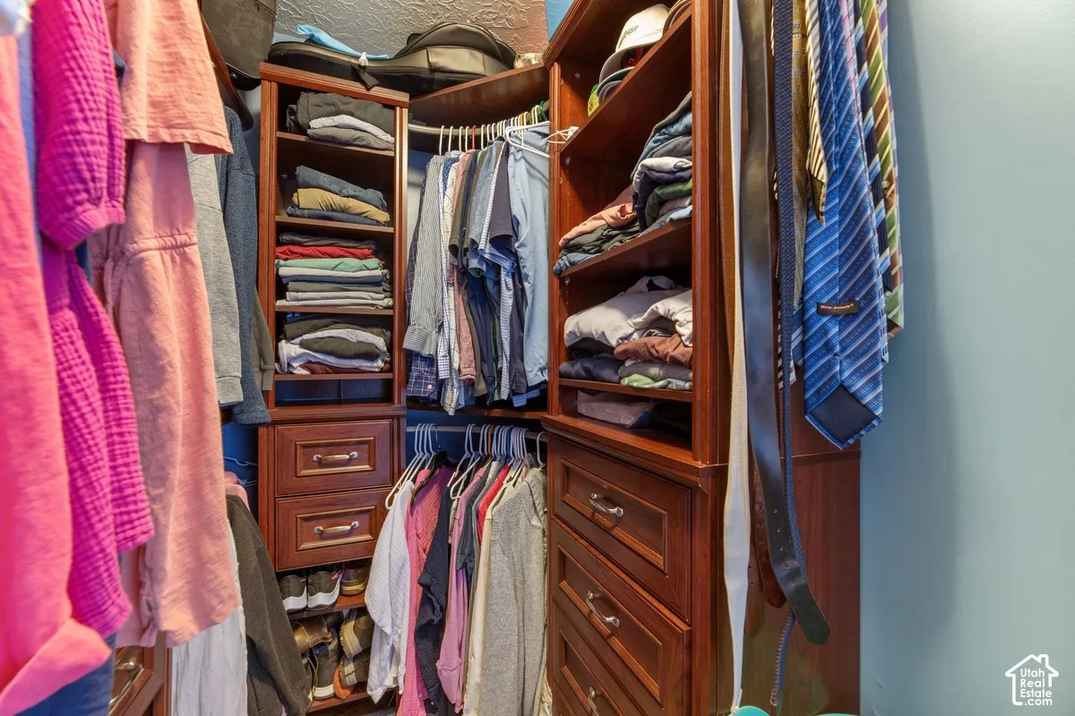 Custom closet system with multiple shelving units, built-in drawers with polished hardware, and ample hanging rod space