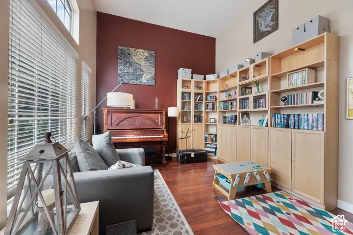Vaulted ceilings with upper windows, extensive wood-finish flooring, and built-in shelving