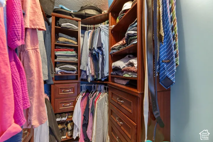 Custom closet system with multiple shelving units, built-in drawers with polished hardware, and ample hanging rod space
