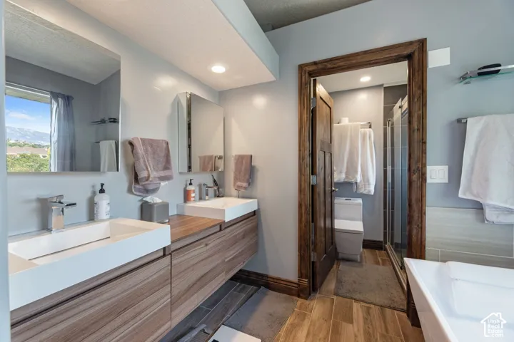 Dual floating vanities with integrated rectangular sinks, modern chrome faucets, and wood-finish cabinetry