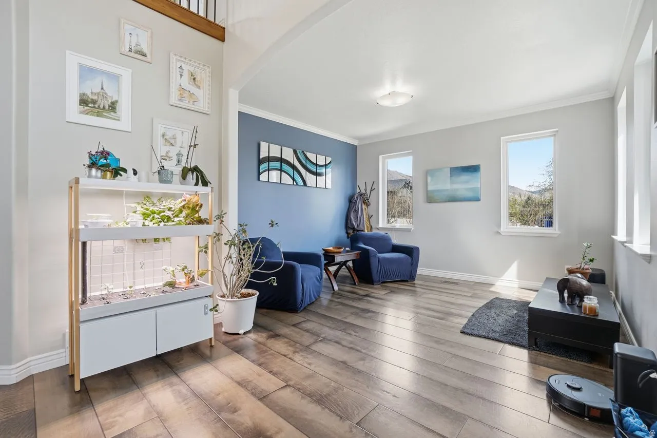Spacious room featuring wood-finish flooring, light gray walls, and multiple windows allowing natural illumination
