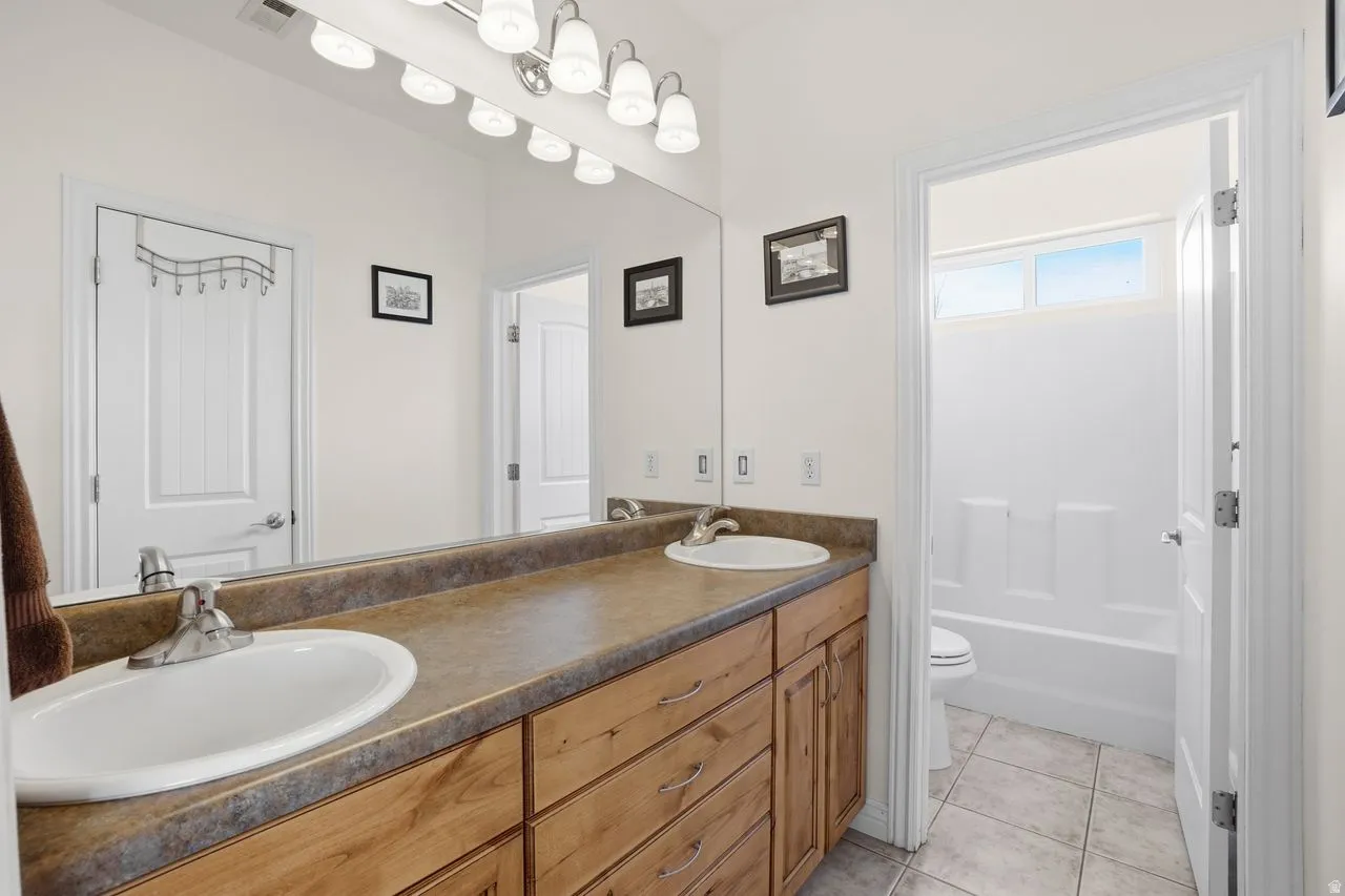 Dual vanity with wood-finish cabinetry and chrome fixtures