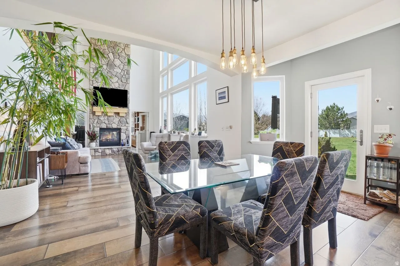Vaulted ceilings, a full-height stone fireplace, and floor-to-ceiling windows with transom elements