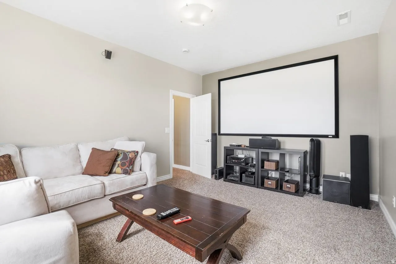 Wall-mounted screen, light-colored walls, recessed lighting, and carpeted flooring